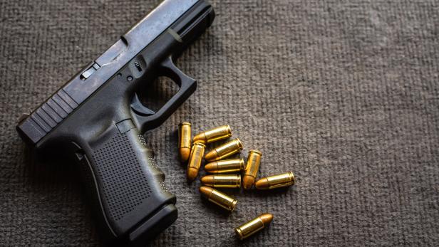 bullets and 9mm gun on black velvet desk