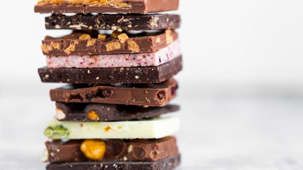 Mehrere unterschiedlich gefüllte und geschichtete Schokoladentafeln sind übereinander gestapelt.