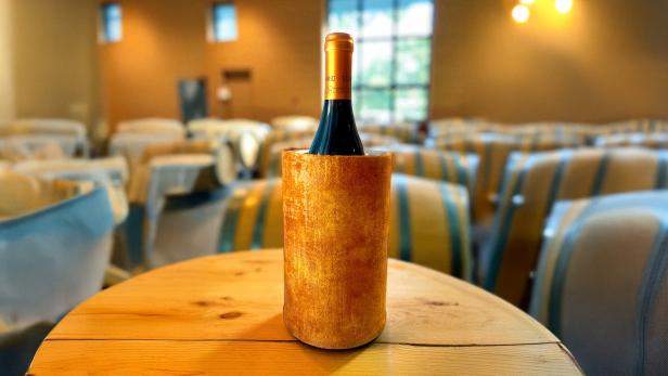 Eine Flasche auf einem Tisch, mit einer Hülle. 