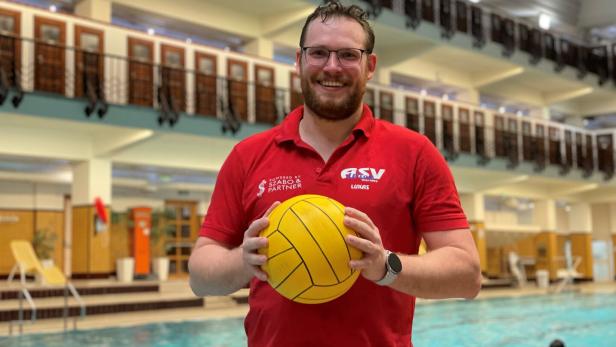 Patrik Raith steht mit einem Wasserball in der Hand am Beckenrand.