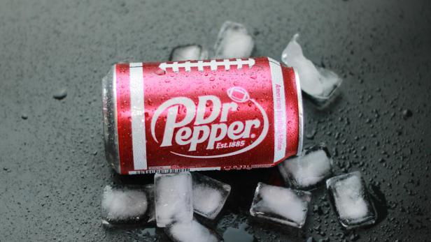 Dr Pepper-Dose im Football-Design liegt auf Eiswürfeln und nasser Oberfläche.