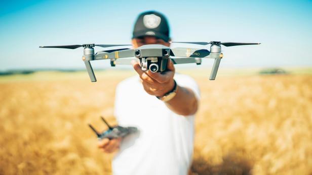 Ein Mann hält eine Drohne in der Hand 