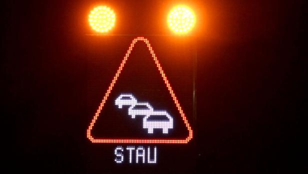 Ein Schild mit der Aufschrift "Stau" im Nachtverkehr