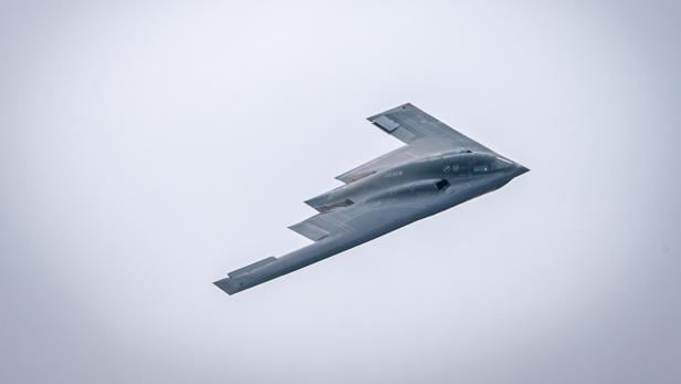 Die B-2 Spirit fliegt als Nurflügler mit charakteristischer Tarnkappenform durch den Himmel.