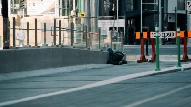 Person lehnt über einer Wand