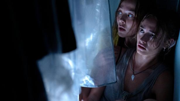 Zwei Mädchen verstecken sich.