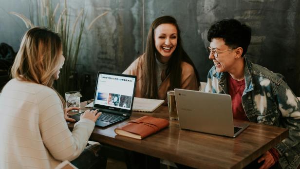 Gruppe von Frauen bei der Arbeit an Laptops