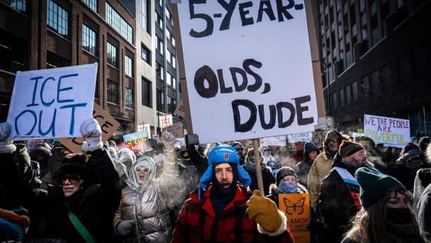 Eine Menschenmenge demonstriert mit Schildern, darunter "5-Year-Olds, Dude" und "ICE Out".