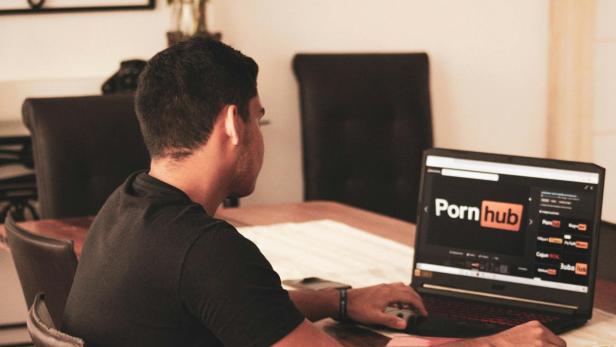 Mann mit geöffneter Pornhub-Webseite. (Symbolbild)