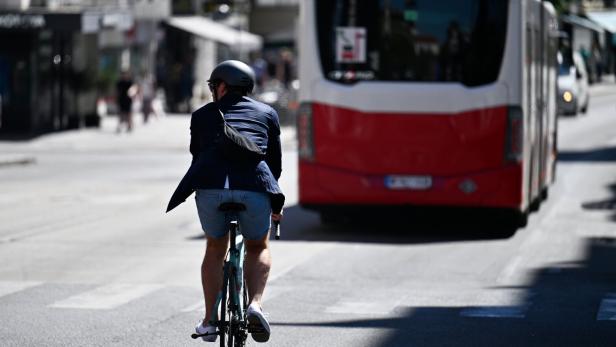 Mann auf einem Fahrrad hinter einem Bus