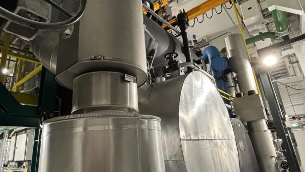 Große silberne Industrieanlagen mit Rohren und Ventilen in einer technischen Anlage.