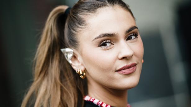 Stefanie Giesinger mit Pferdeschwanz trägt auffälligen Ohrschmuck und eine Halskette.