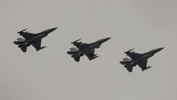 Drei Militärjets fliegen in Formation durch einen grauen, wolkigen Himmel.