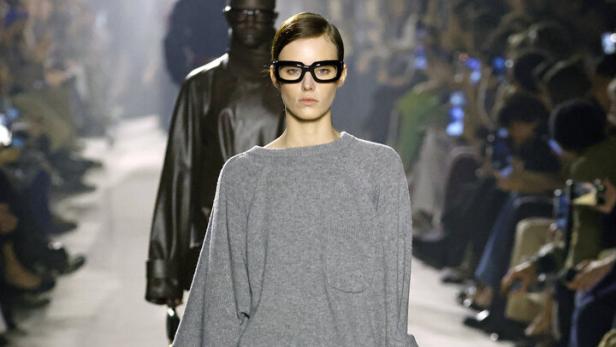 Model im langen grauen Pulli mit halterlosen Strümpfen auf dem Laufsteg