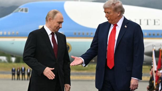 Donald Trump und Wladimir Putin stehen vor einem Flugzeug.