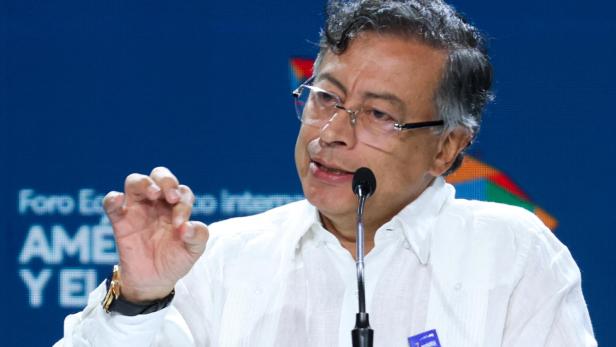 Gustavo Petro spricht vor blauem Hintergrund in ein Mikrofon.