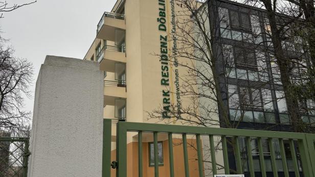 Grüner Zaun vor einem gelben Gebäude