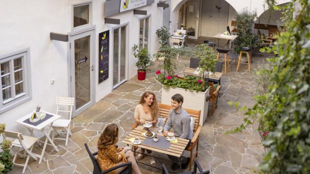 Der Innenhof eines Restaurants mit Tischen und Menschen.