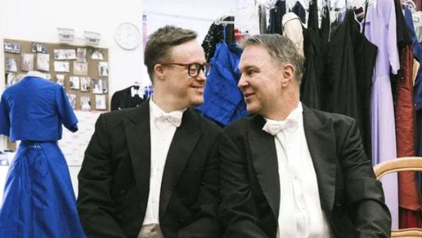 Zwei Herren im Frack sitzen auf einer Bank