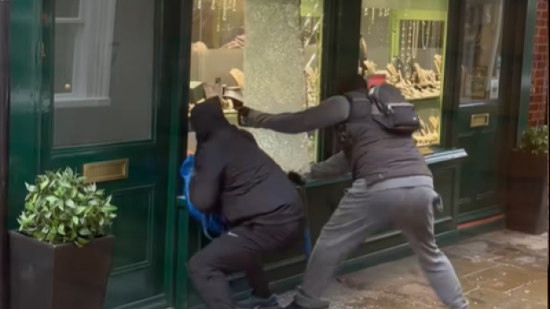 Zwei maskierte Männer schlagen mit einem Hammer die Schaufensterscheibe des Juweliergeschäfts Gregory & Co in Richmond ein und greifen nach Schmuck.