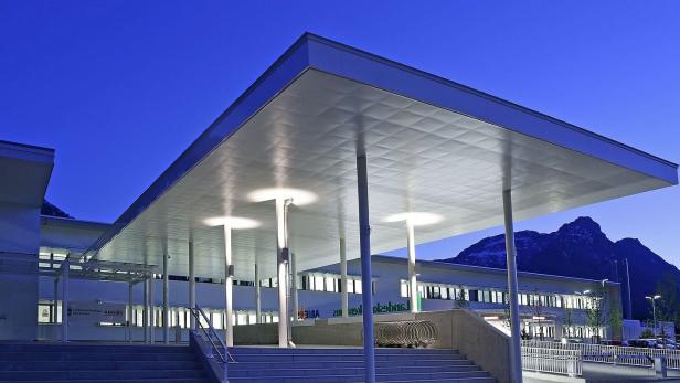 Das Landeskrankenhaus Bad Aussee mit großem Vordach und Bergkulisse im Abendlicht.