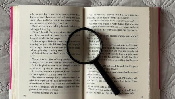 Aufgeschlagenes Buch mit Lupe darauf