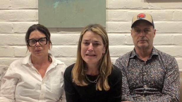 Moderatorin Savannah Guthrie mit ihren Geschwistern Annie und Camron sitzen nebeneinander auf einem Sofa und halten Blätter in den Händen, Guthrie wirkt emotional bewegt.