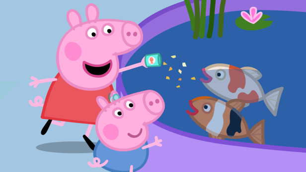 Peppa und ihr Bruder Schorsch, der ein Hörgerät trägt, füttern gemeinsam Fische an einem Teich.