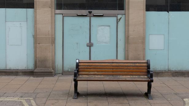 Leere Bank vor leerstehendem Geschäft