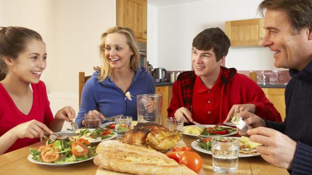 Teenage Family Eating Lunch Together In Kitchen