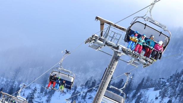 zu sehen sind Kinder und Erwachsene in einem Sessellift am Kasberg im Jahr 2021.
