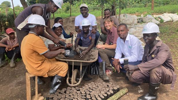 Diana Leitzinger unter Mitarbeitern einer Farm mit Bananensetzlinge 