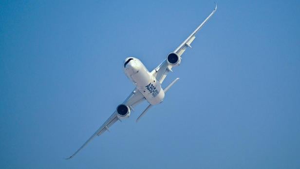 Ein weißes A350-1000 Flugzeug fliegt vor einem wolkenlosen, blauen Himmel.