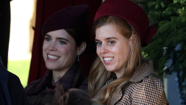 Prinzessin Eugenie und Prinzessin Beatrice lächeln mit Hüten und karierten Mänteln.