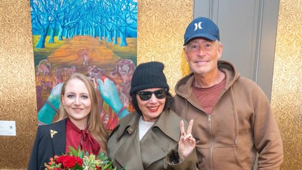 Drei Personen mit Blumenstrauß