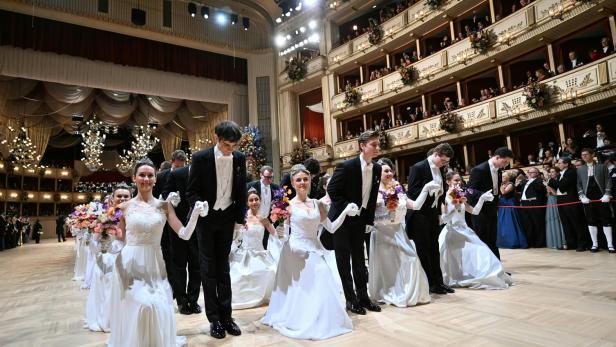 Mehrere Paare in festlicher Kleidung knien auf einem Ballsaal, umgeben von elegantem Publikum auf Balkonen.