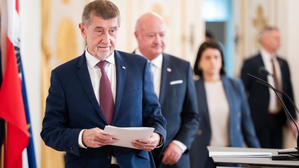 Zwei Männer im Anzug, im Hintergrund eine Frau