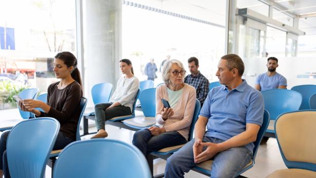 Senior woman in the waiting room at the hospital asking for help filling a form