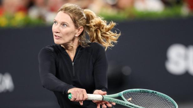 Steffi Graf mit blondem Pferdeschwanz schlägt einen Ball mit einem Tennisschläger.