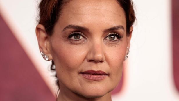Nahaufnahme von Katie Holmes mit hochgesteckten braunen Haaren und Ohrringen.