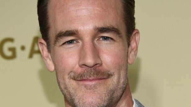 Van Der Beek mit kurzem braunem Haar, Bart und kariertem Sakko vor hellgelbem Hintergrund.