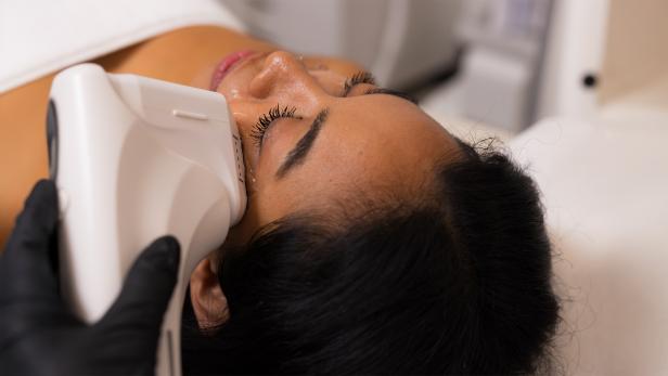 Eine Frau wird im Gesicht behandelt.