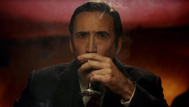 Nicolas Cage führt ein Glas zum Mund