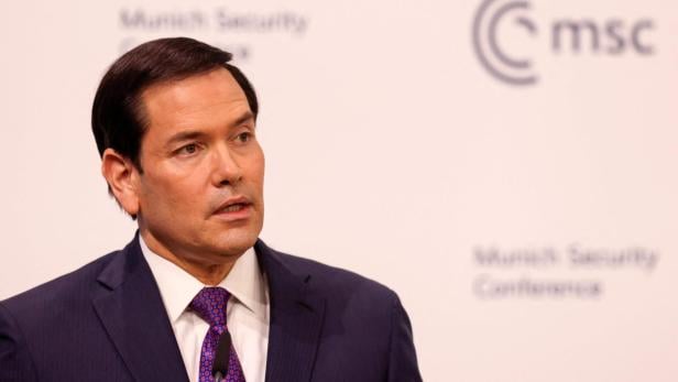 Ein Mann im Anzug spricht vor dem Hintergrund der Münchner Sicherheitskonferenz.