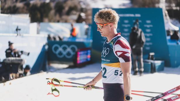 Langläufer Mika Vermeulen trägt seine Ski.