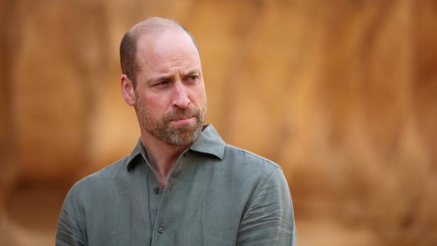 Prinz William blickt mit Bart und grünem Hemd nach links.