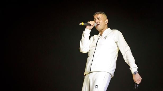 Haftbefehl steht auf der Bühne und performt.