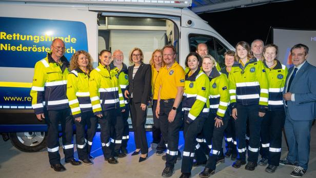 Mitglieder der Rettungshunde Niederösterreich und Landeshauptfrau Johanna Mikl-Leitner stehen vor dem neuen Einsatzleitfahrzeug bei der offiziellen Übergabe in Sieghartskirchen.