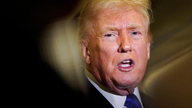 U.S. President Donald Trump speaks to reporters onboard Air Force One