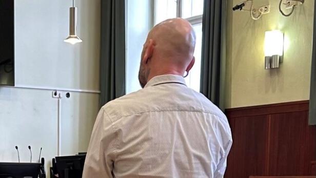 Ein Angeklagter im Gerichtssaal von hinten